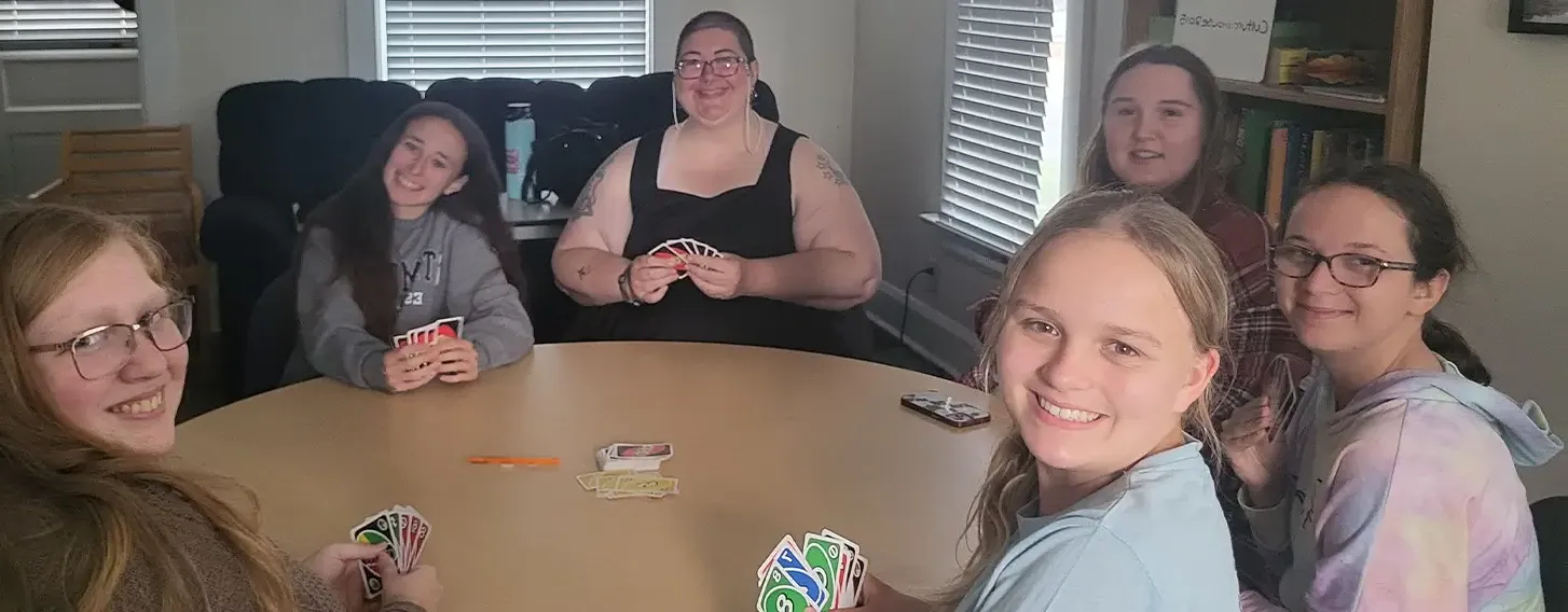 A group of students playing a card came at a table together